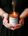 Cashmere soy candle styled in ladies hands with a black dress and silver rings