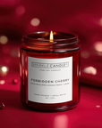 Sparkle Candle Co. Forbidden Cherry candle in a red jar with a blurred red background