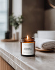 Candle labeled 'Lavender + Eucalyptus' on a marble surface with a blurred background
