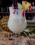 Tropical cocktail with pineapple garnish on a bar counter, labeled with ingredients.