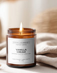 Vanilla cream candle in a brown glass jar with a label, surrounded by neutral decor.