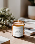 Candle labeled 'Wild Grape' on a wooden surface with a blurred background