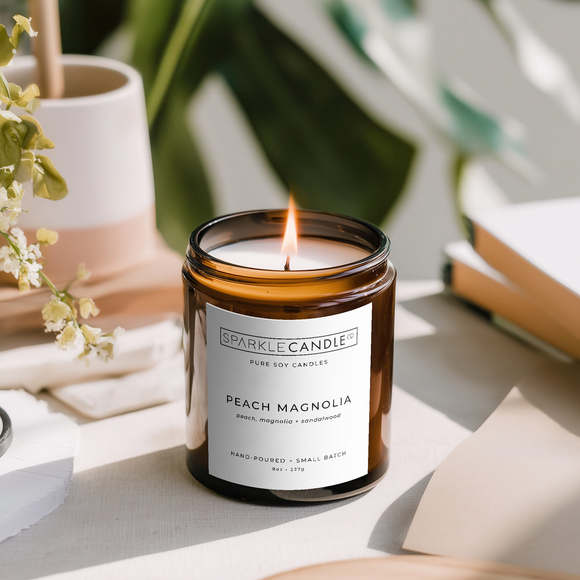 Sparkle Candle Peach Magnolia candle on a table with a blurred background