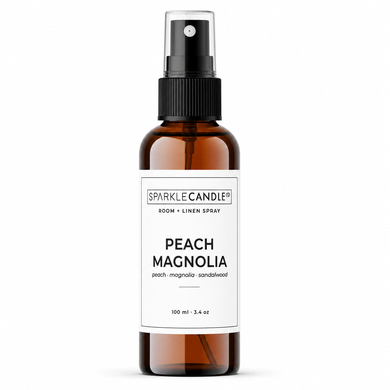 Brown spray bottle with a white label for peach magnolia room spray on a white background