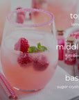 Pink lemonade with raspberries and sugar crystals on a white surface