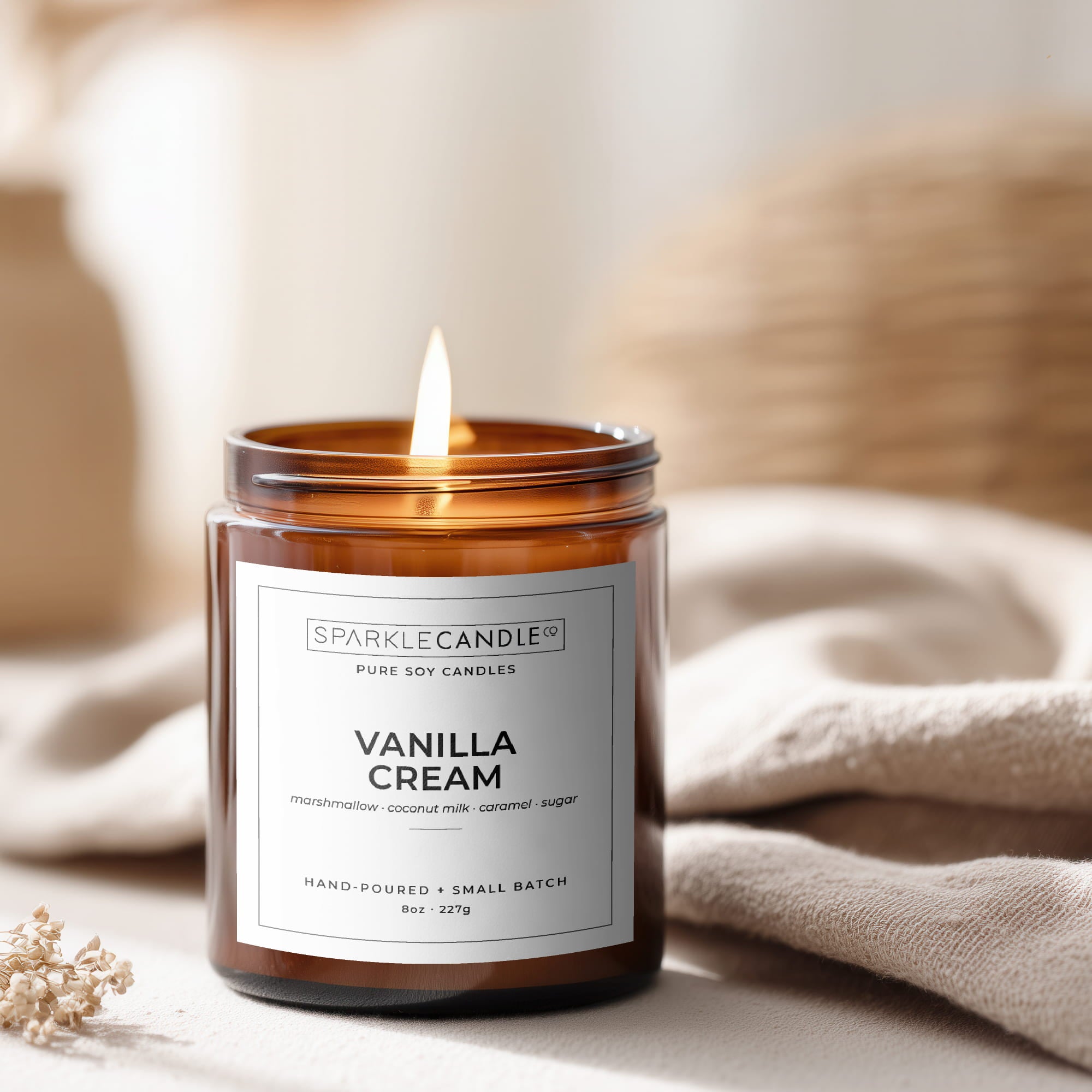 Vanilla cream candle in a brown glass jar with a label, surrounded by neutral decor.
